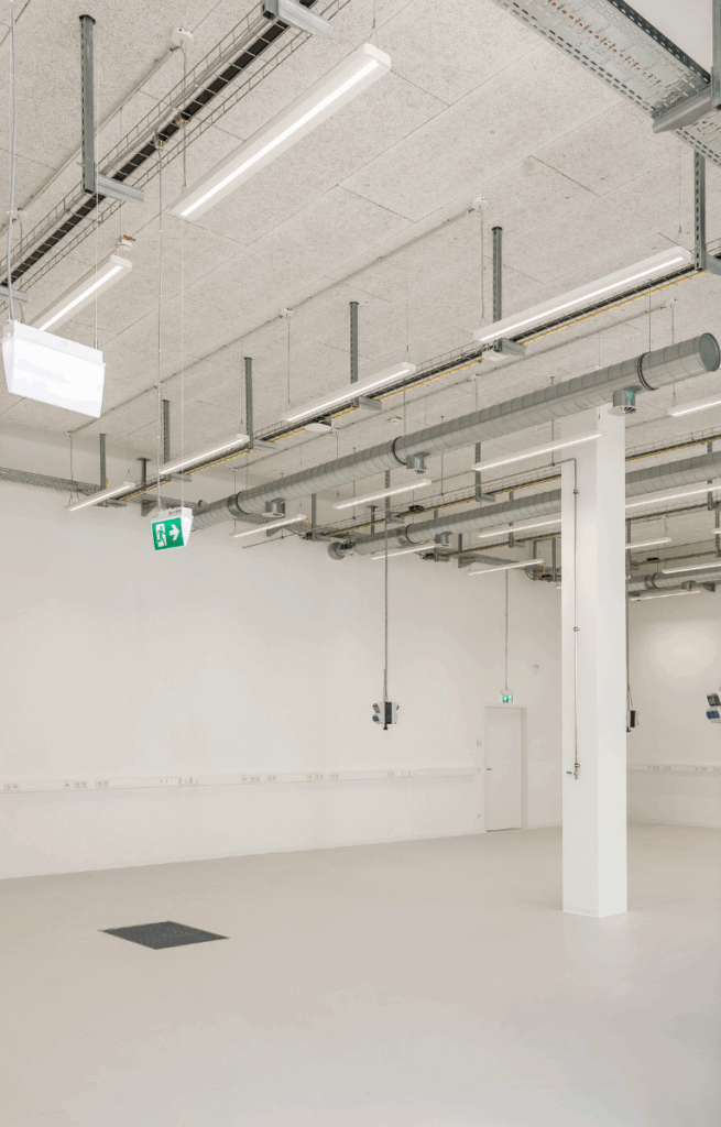 Großer Innovationsraum mit Industrieverkabelung an der Decke und zahlreichen Stromanschlüssen.