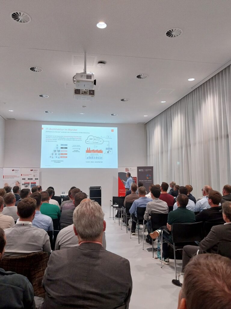 Fachvortrag im RITZ Innovationszentrum zum Wandel der IT-Architektur. Der Raum ist voll besetzt, das Publikum folgt konzentriert der Präsentation.