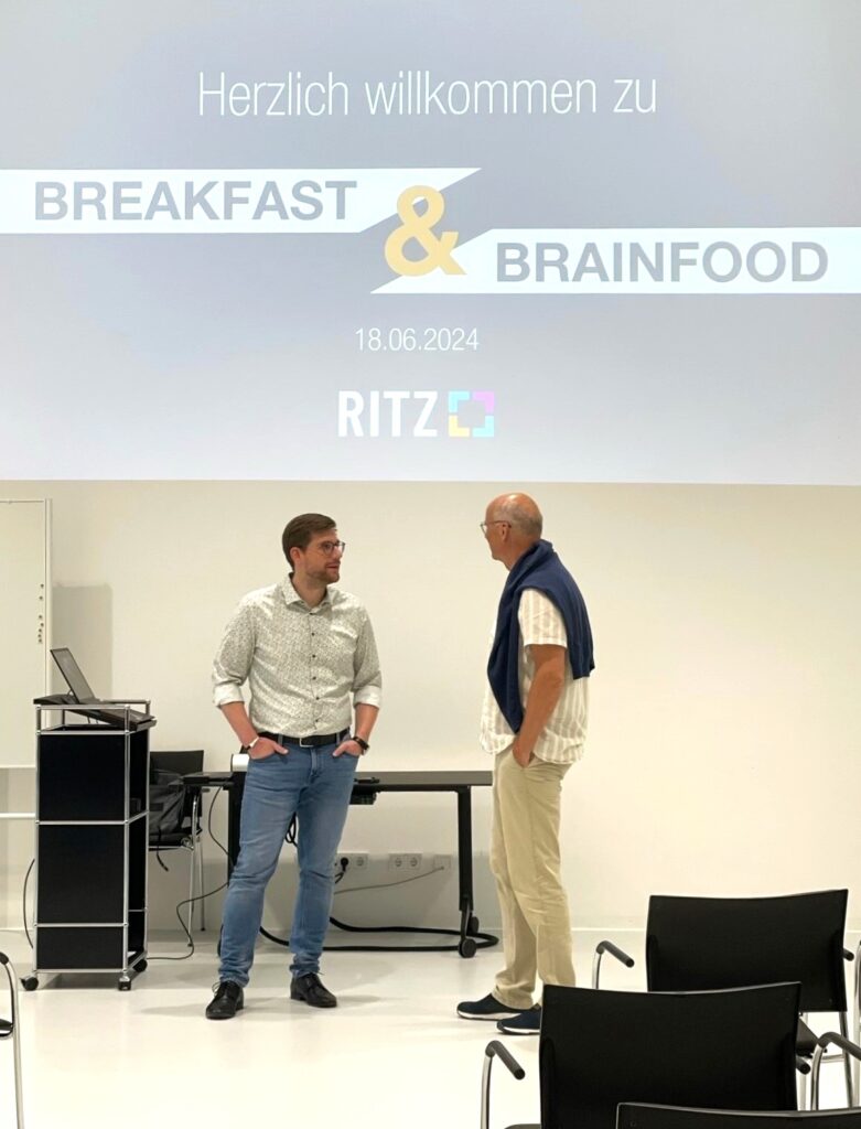 Sascha Schmidt (links) im Gespräch mit einem Gast vor Beginn der Veranstaltung ‚Breakfast & Brainfood‘ am 18. Juni 2024 im RITZ Friedrichshafen