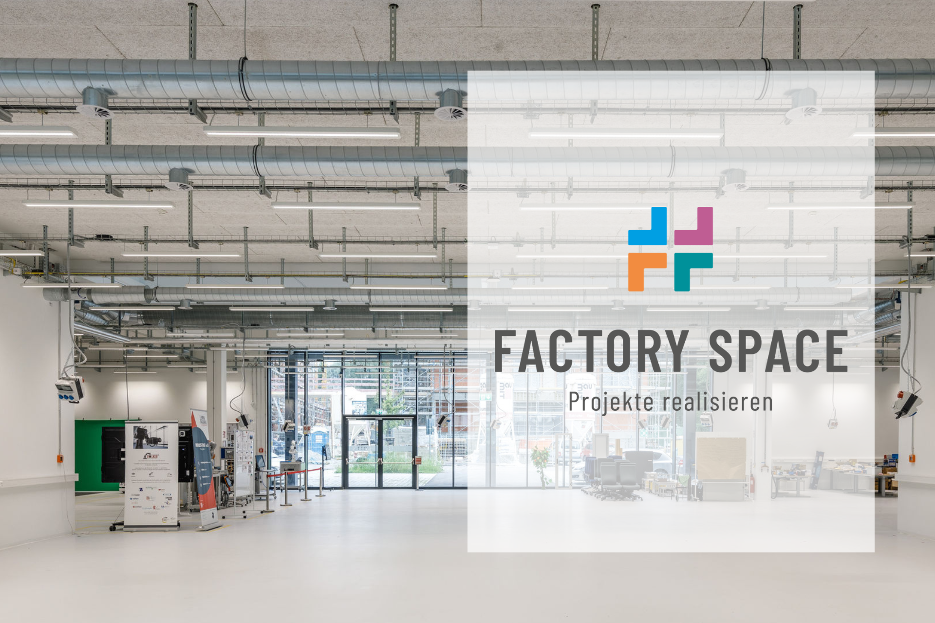 Innenaufnahme des Factory Space im RITZ mit Blick auf die großzügige Werkhalle, ausgestattet mit technischer Infrastruktur. Im Vordergrund ein transparenter Texteinleger mit dem Logo und der Aufschrift ‚Factory Space – Projekte realisieren‘.
