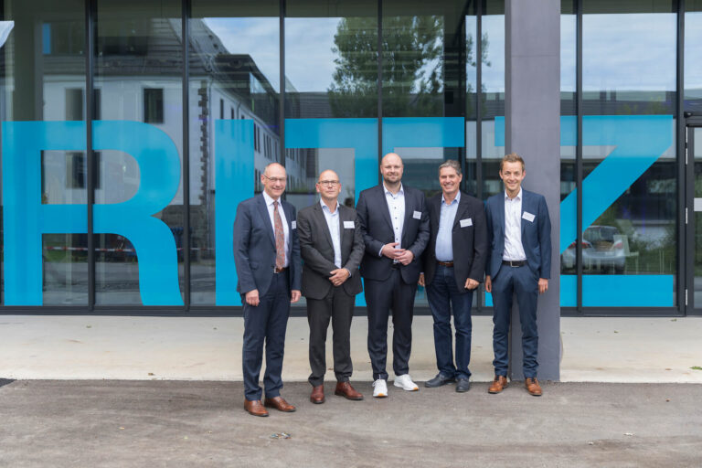 Fünf Männer stehen nebeneinander vor der Glasfassade des RITZ Innovationszentrums. Von links nach rechts: Landrat Lothar Wölfle, Dr. Arndt Oschmann (Ministerium für Wirtschaft, Arbeit und Tourismus Baden-Württemberg), Marian Duram (RITZ), Bürgermeister Dieter Stauber und Thomas Schorer.