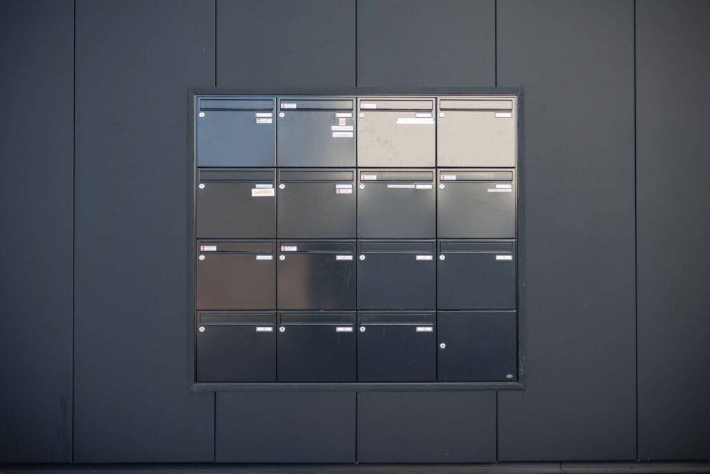 15 schwarze Briefkästen des RITZ an der Hauswand