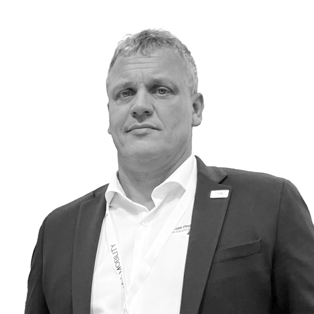 Schwarz-weiß-Porträt von Christian Meyer. Er trägt ein Sakko mit Hemd und Namensschild sowie ein Konferenz-Lanyard.