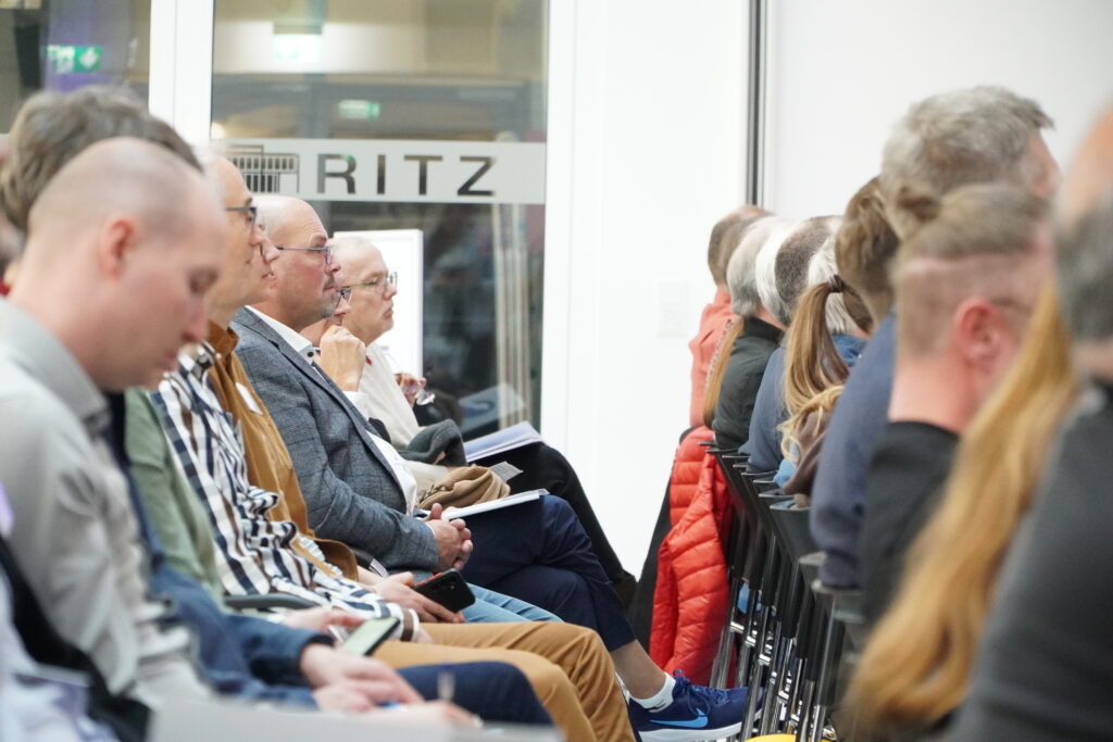 Publikum sitzt aufmerksam bei der Veranstaltung „Wer nicht innoviert, verliert“ im RITZ und verfolgt einen Fachvortrag.