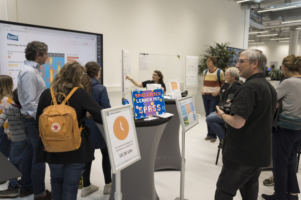 Besucherinnen und Besucher testen einen interaktiven Spielstand bei der Langen Nacht der Technik 2023 im RITZ.