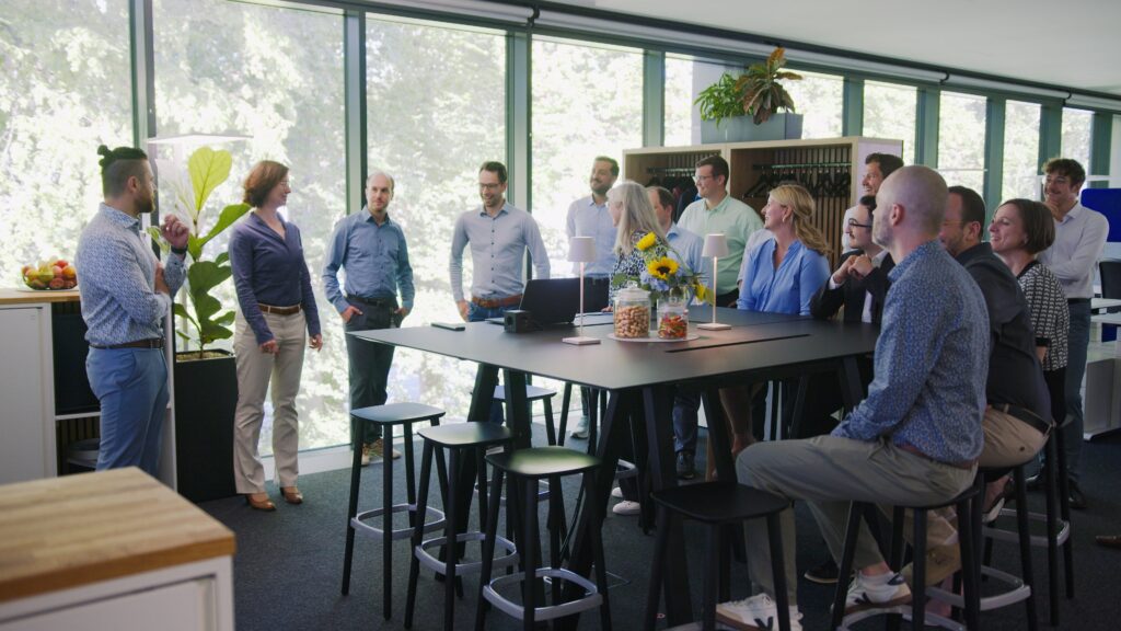 Das Tri.Merge-Team, versammelt um einen großen Stehtisch